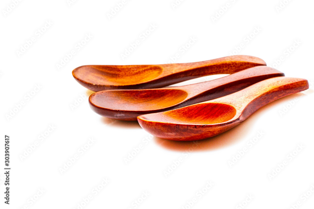 Three wooden spoons on a white background made of natural mahogany. Three wooden spoons on a white background made of natural mahogany.