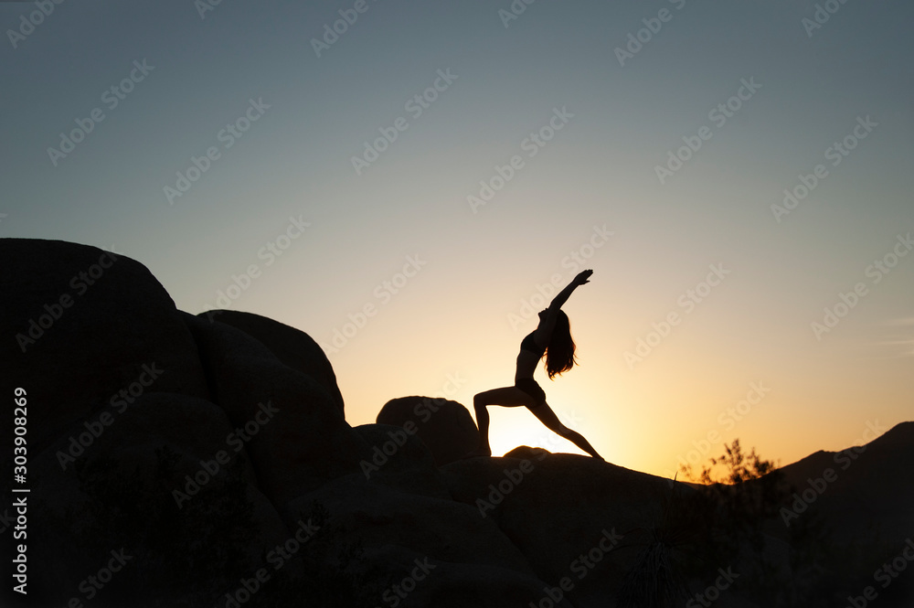 Yoga woman silhouette in the desert sunset. 