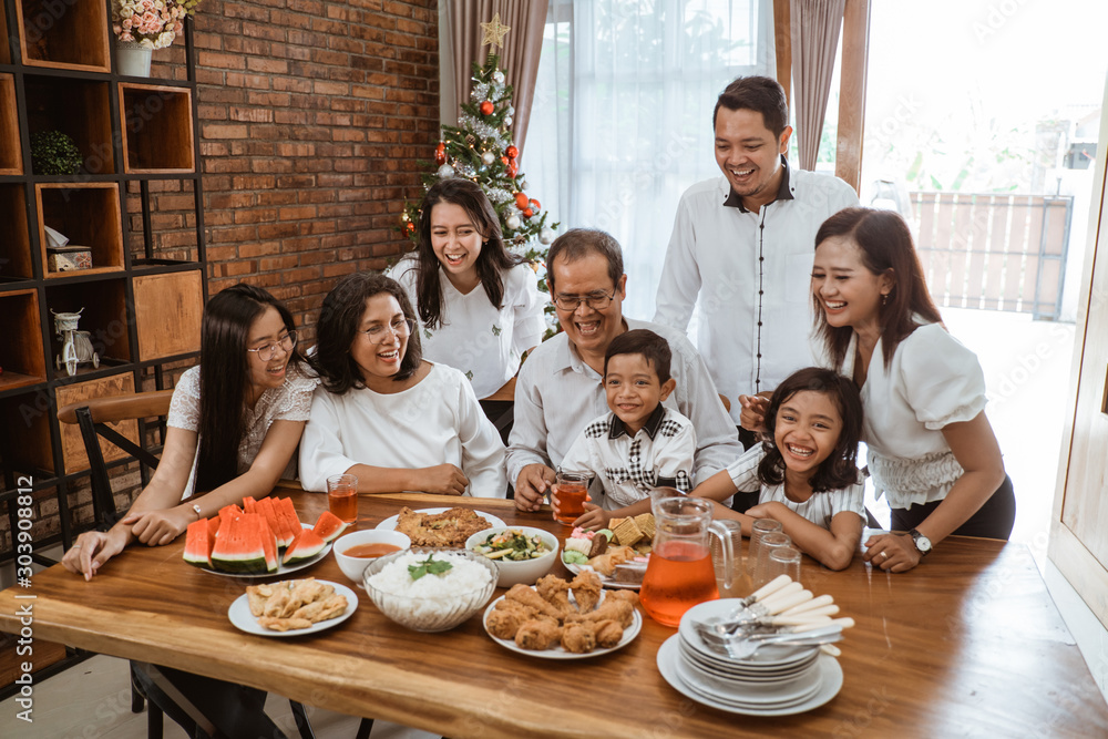Obraz premium asian family fun having lunch with friends in diningroom together on christmas celebration