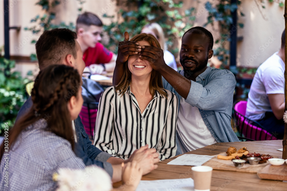 Φωτογραφία Surprise from african friend to a caucasian girl at the open air terrace of a  r
