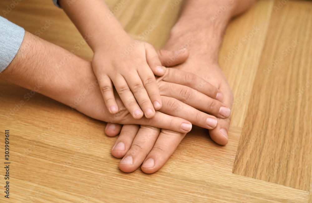 Happy family holding hands on wooden background, closeup Happy family holding hands on wooden background, closeup