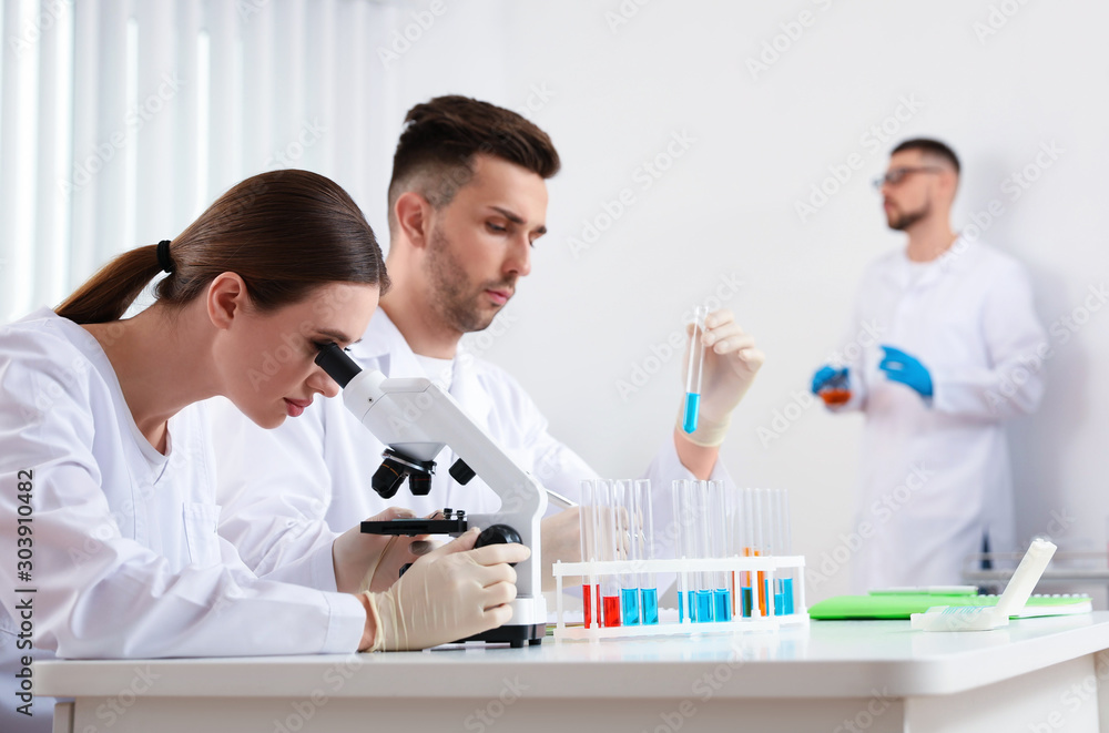 Medical students with microscope in modern laboratory Medical students with microscope in modern laboratory