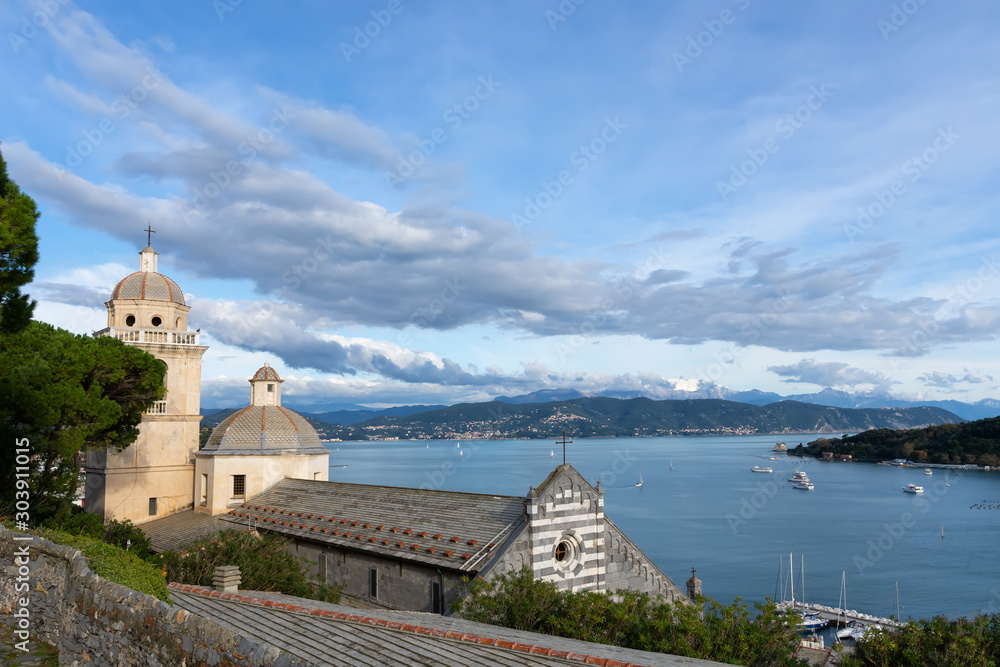  View of the Bay of Poets on the Ligurian Sea from the city of Portovenere, Church of San Lorenzo against a blue sea background
