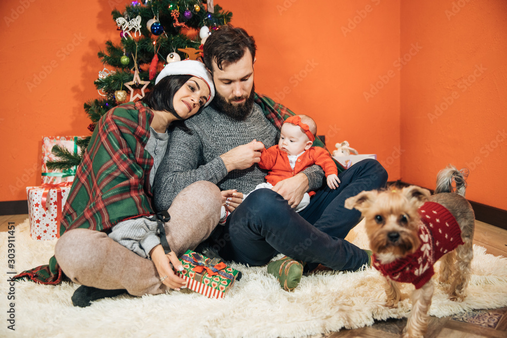 Φωτογραφία young family with a child near the Christmas tree, mom dad and their newborn dau