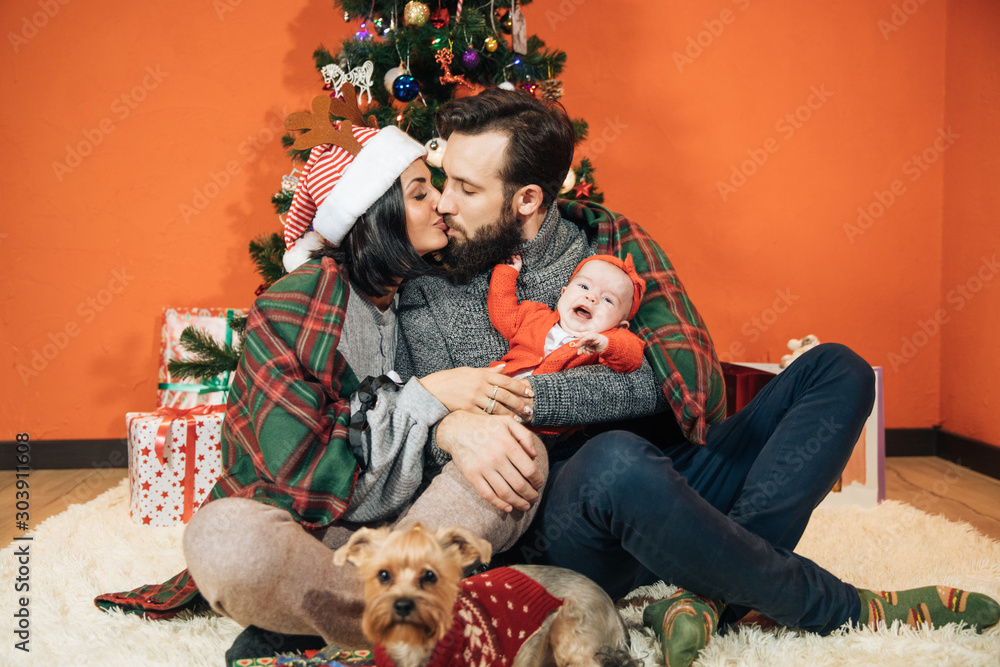 Φωτογραφία young family with a child near the Christmas tree, mom dad and their newborn dau