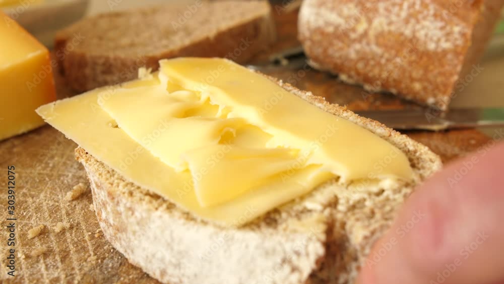 Putting dutch cheese on bread in close-up. Putting dutch cheese on bread in close-up.