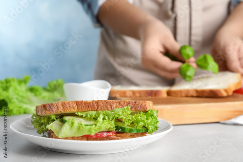 Tasty sandwich on light grey marble table, closeup