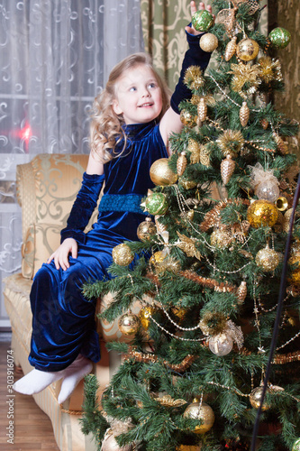 girl near a decorated Christmas tree