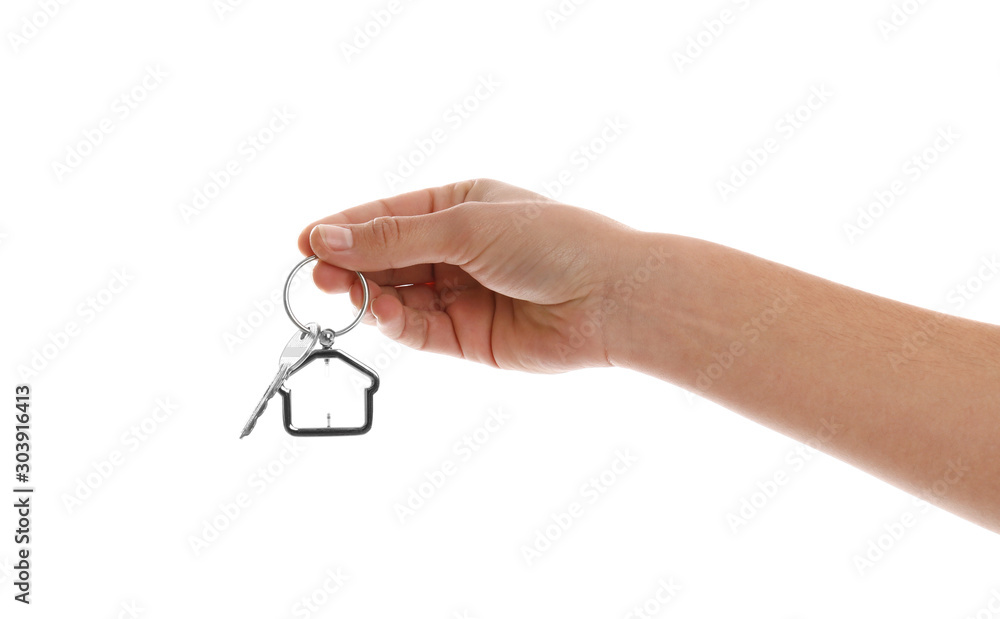 Real estate agent holding house key with trinket on white background, closeup Real estate agent holding house key with trinket on white background, closeup
