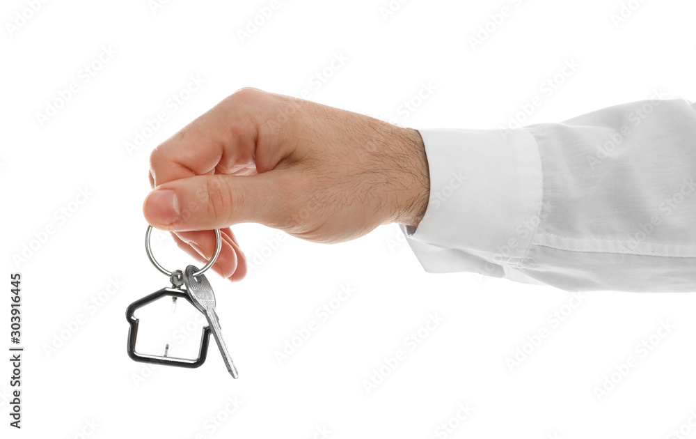Real estate agent holding house key with trinket on white background, closeup Real estate agent holding house key with trinket on white background, closeup