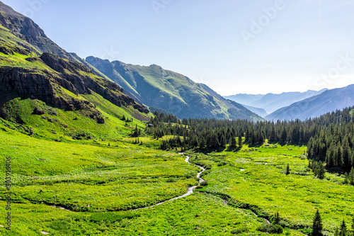 High angle aerial view of river flowing through meadow field on trail to Ice lake near Silverton, Colorado in August 2019 summer