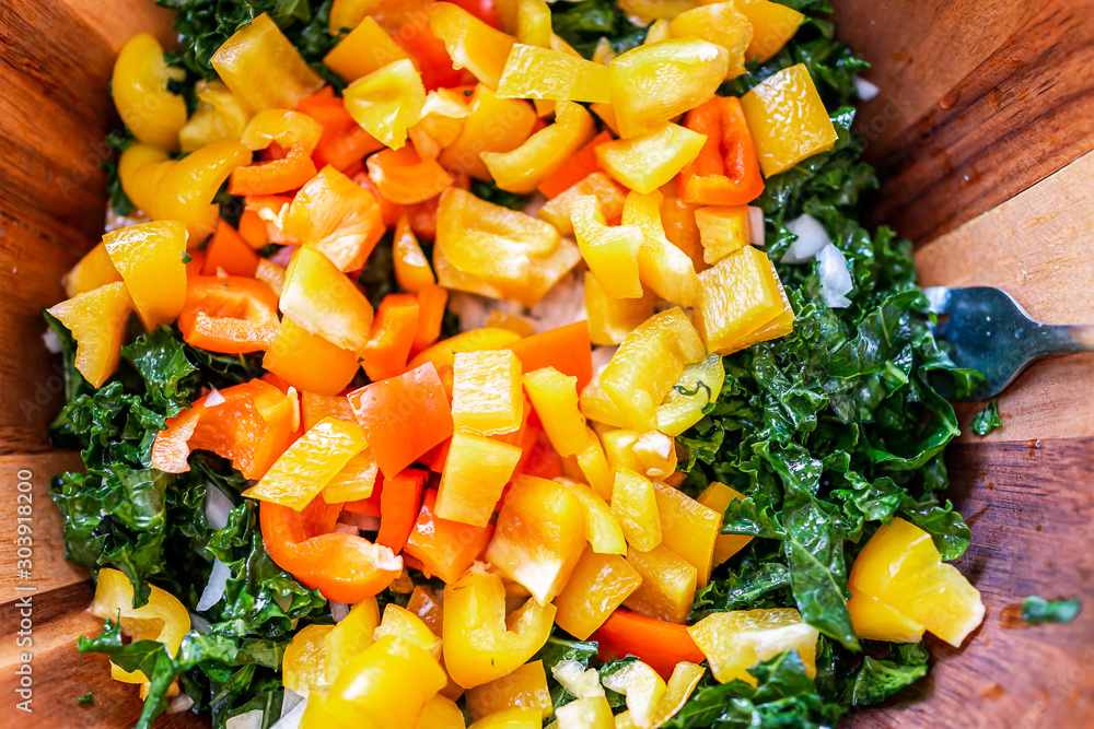 Φωτογραφία Closeup macro flat top view of wooden salad bowl with chopped green kale and ora