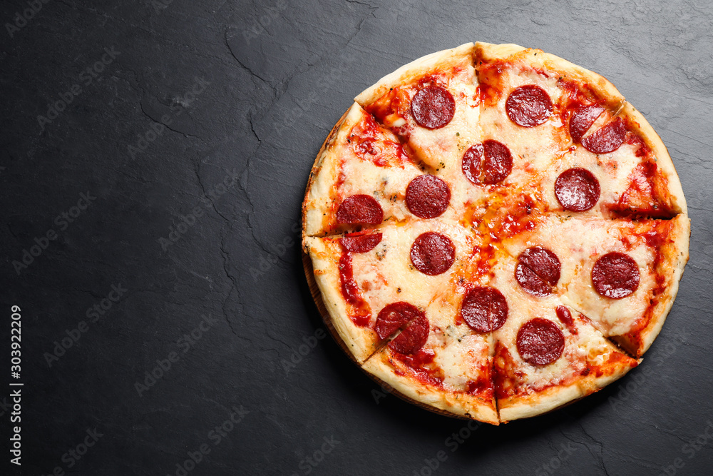 Hot delicious pepperoni pizza on dark table, top view. Space for text