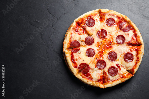 Hot delicious pepperoni pizza on dark table, top view. Space for text