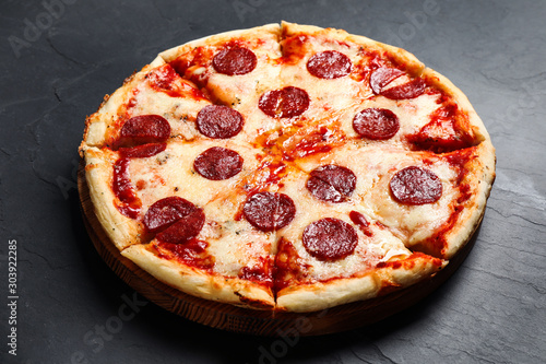 Hot delicious pepperoni pizza on dark table