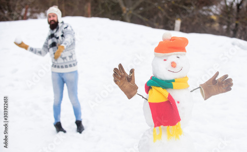 Real feelings. winter holiday outdoor. warm sweater in cold weather. happy hipster ready to celebrate xmas. winter season activity. its christmas. man play with snow. bearded man build snowman
