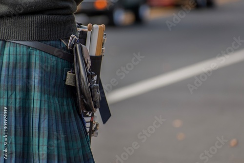 Photo Scottish drum player in full uniform walking down the road during a Veterans Day parade