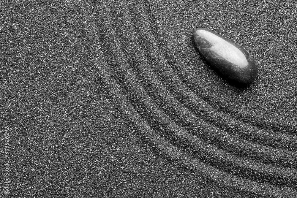 Obraz premium Zen garden stone on black sand with pattern, top view