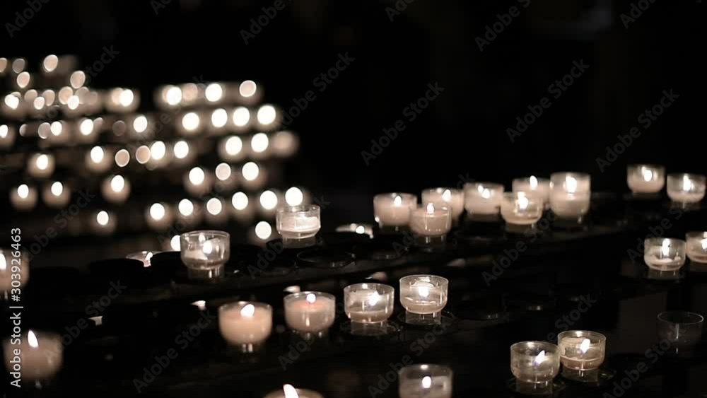 Silhouettes of visitors behind multiple lighted candles in cathedral catholic orthodox Christianity and peaceful scene Silhouettes of visitors behind multiple lighted candles in cathedral catholic orthodox Christianity and peaceful scene