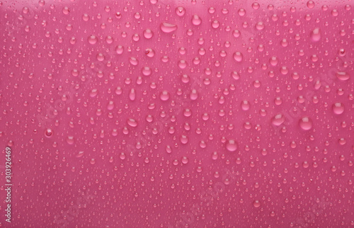Water drops on pink background, top view