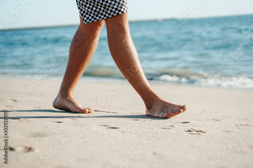 Young man walking on the beach.
