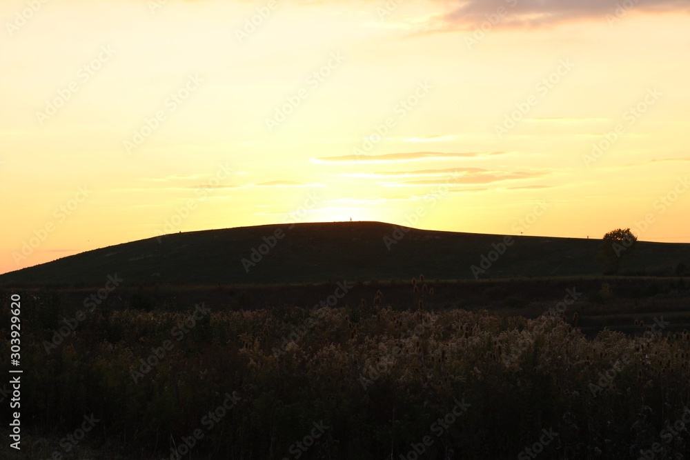 The bright sunset sky over the hill landscape in country.