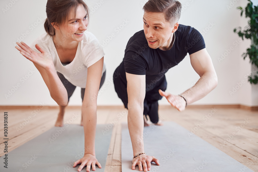 Athletic woman and man shaking hands on sports mat