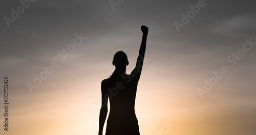 Strong determined female with hand raised to the sky. People power concept. 