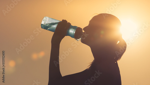 Woman drinking bottle of water outdoors