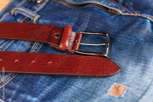 men's leather trouser belt in the background of denim, men's closet, jeans
