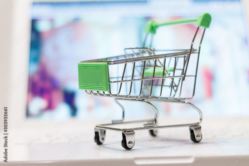supermarket shopping cart on laptop background close-up, macro, online shopping concept and purchasing power, consumer shopping cart supermarket shopping cart on laptop background close-up, macro, online shopping concept and purchasing power, consumer shopping cart