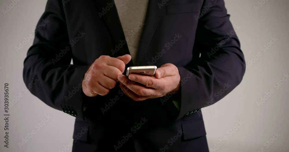 adult man is holding modern cell phone and showing thumbs up, detail view of hands and body adult man is holding modern cell phone and showing thumbs up, detail view of hands and body