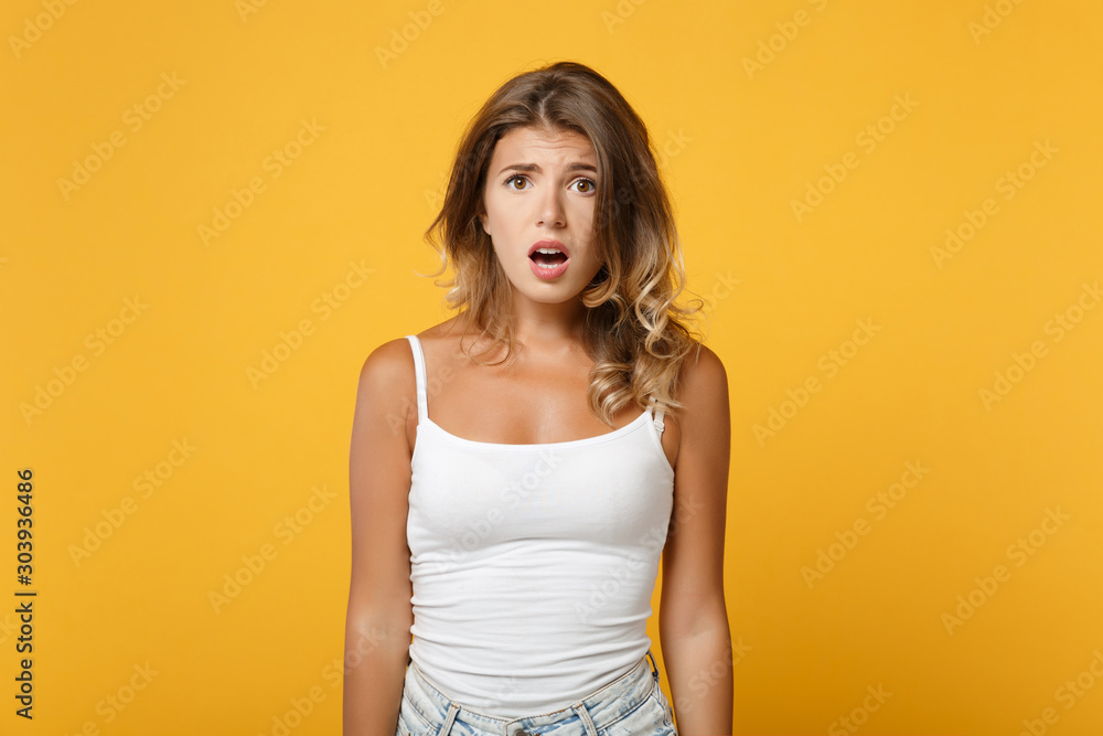 Bewildered young woman girl in light casual clothes posing isolated on yellow orange wall background, studio portrait. People sincere emotions lifestyle concept. Mock up copy space. Looking camera. Bewildered young woman girl in light casual clothes posing isolated on yellow orange wall background, studio portrait. People sincere emotions lifestyle concept. Mock up copy space. Looking camera.