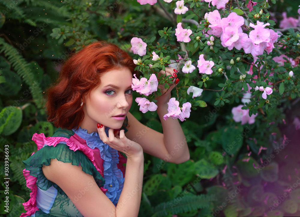 beautiful red-haired girl in arranger where azalea blooms in a colorful flying dress beautiful red-haired girl in arranger where azalea blooms in a colorful flying dress
