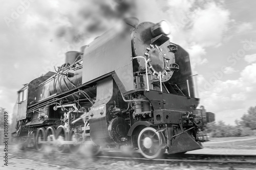 vintage steam train hurtling at speed along the rails close-up, retro vehicle, steam engine, black and white