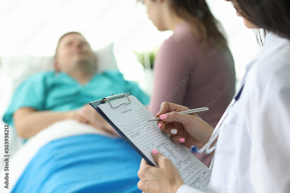 Doctor filling form about condition of patient Doctor filling form about condition of patient
