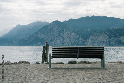 Bench by Lake Garda facing villages on the mountain photo