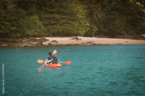 Couple canoeing or kayaking at sea island, Thailand.