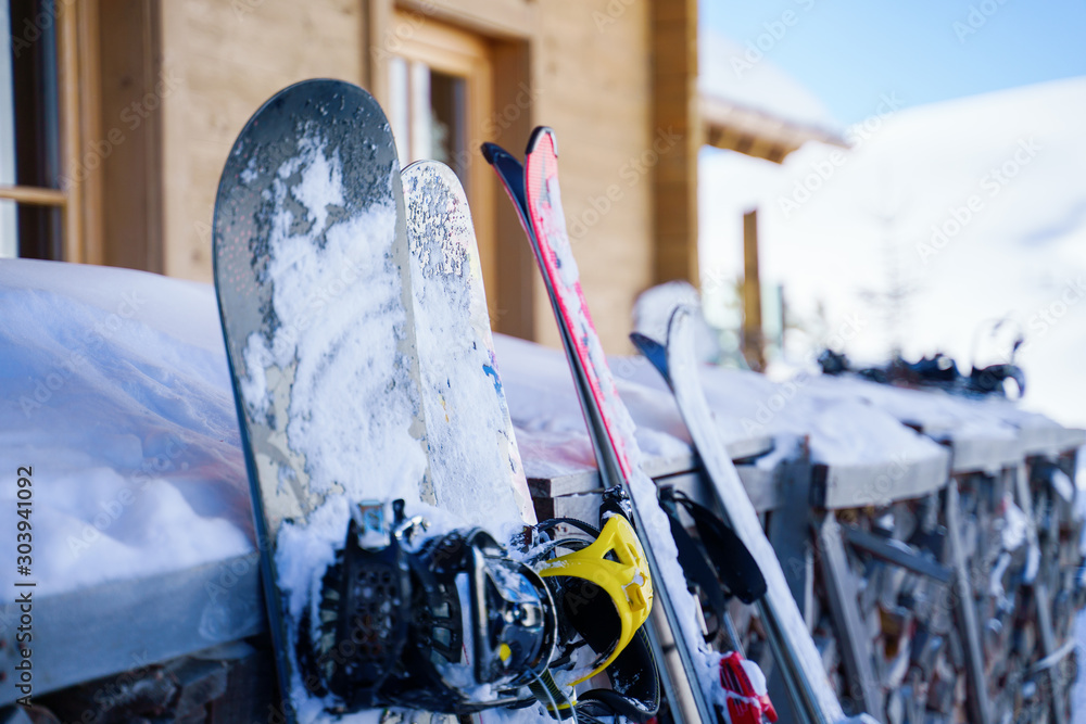 Image of multi-colored skis and snowboards in snow at winter resort in afternoon. - obrazy, fototapety, plakaty 
