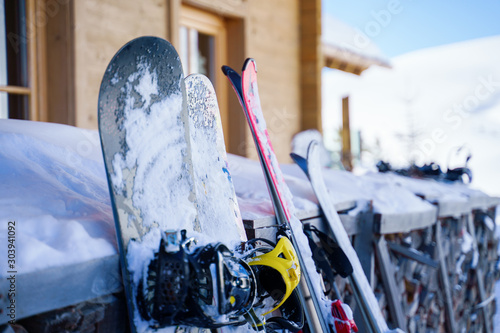 Image of multi-colored skis and snowboards in snow at winter resort in afternoon. photo