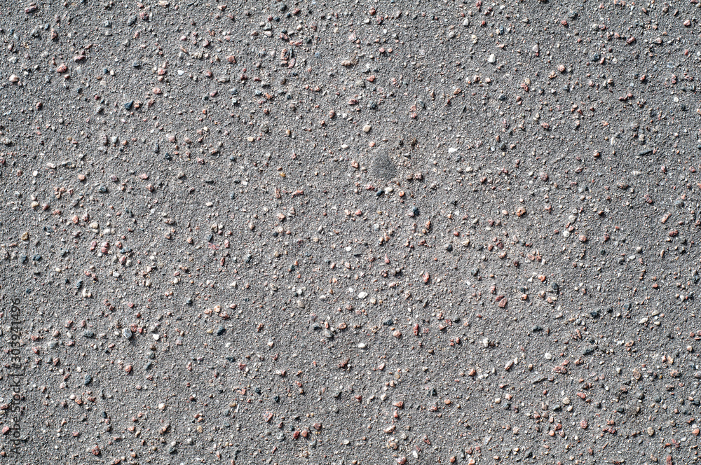 The texture of the background of stone black gray asphalt road with small pebbles.