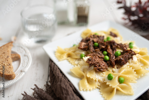 Beef tips over bow tie pasta and Alfredo sauce