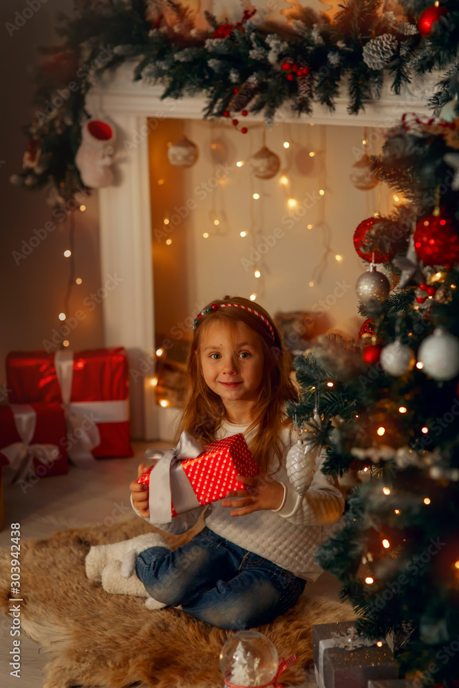 Happy little girl near fireplace at Christmas eve Happy little girl near fireplace at Christmas eve