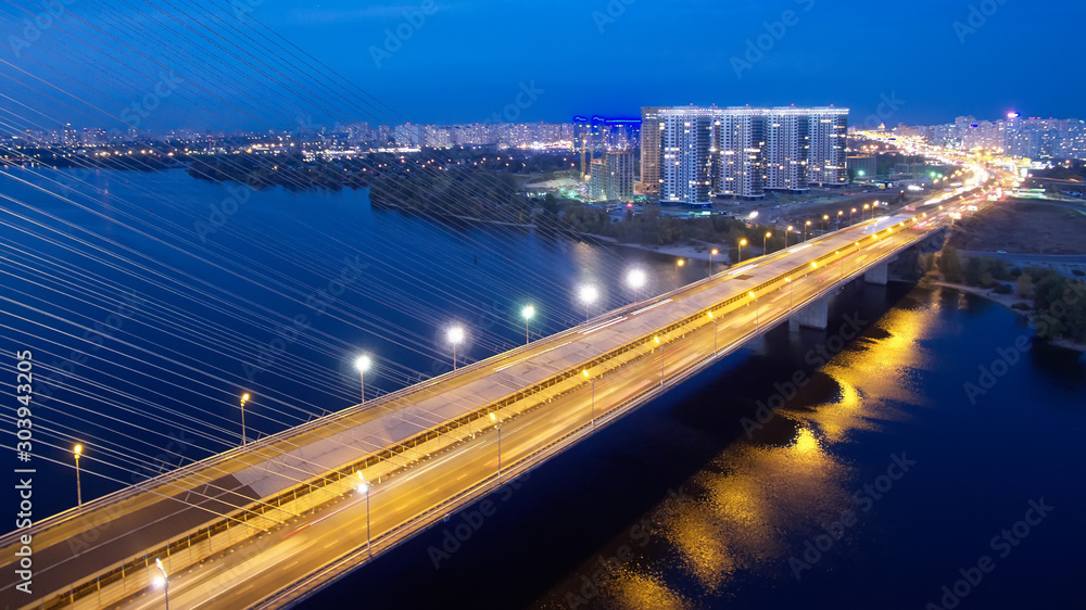 Fototapeta premium Automobile and railroad bridge in Kiev, the capital of Ukraine. Bridge at sunset across the Dnieper River. Kiev bridge against the backdrop of a beautiful sunset in Kiev. Bridge in evening sunshine