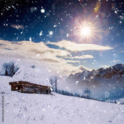 Winter postcard of cottage in the mountains at sunrise. Christmas concept. © belyaaa
