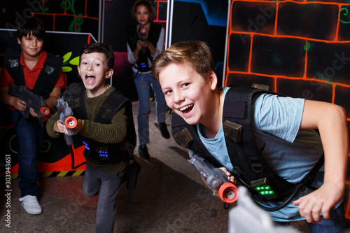 boy aiming laser gun at other players during lasertag game © JackF