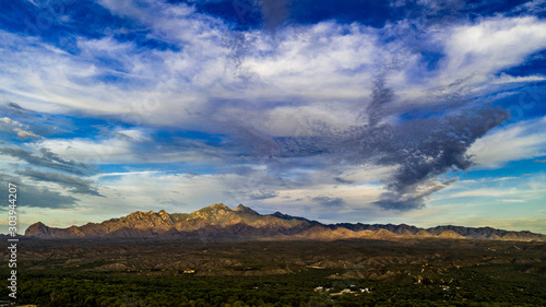 Sunset, aerial landscapes of Santa Rita Mountains from above Tubac, Arizona with warm , golden plains, purple mountains, blue sky with colorful clouds on a Fall day  photo