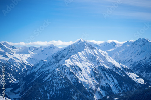 Photo of picturesque highlands with snow mountains and blue sky