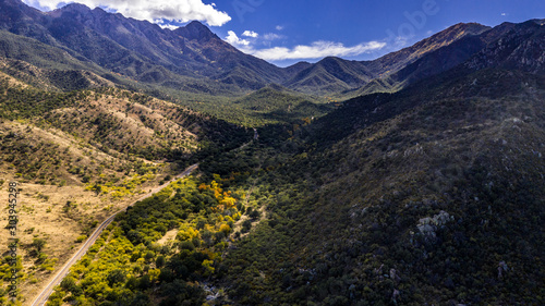 Aerial panorama of Madera Canyon in the Santa Rita Mountains  Arizona in the Fall with purple mountains  green  yellow  orange trees and bushes  blue sky