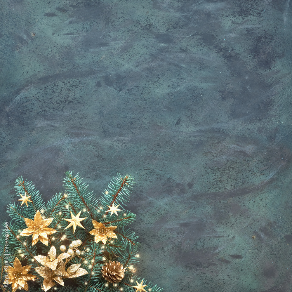 Φωτογραφία Christmas or New Year panoramic background with fir twigs decorated with golden trinkets, flowers, pine cones and Xmas lights on abstract dark textured background
